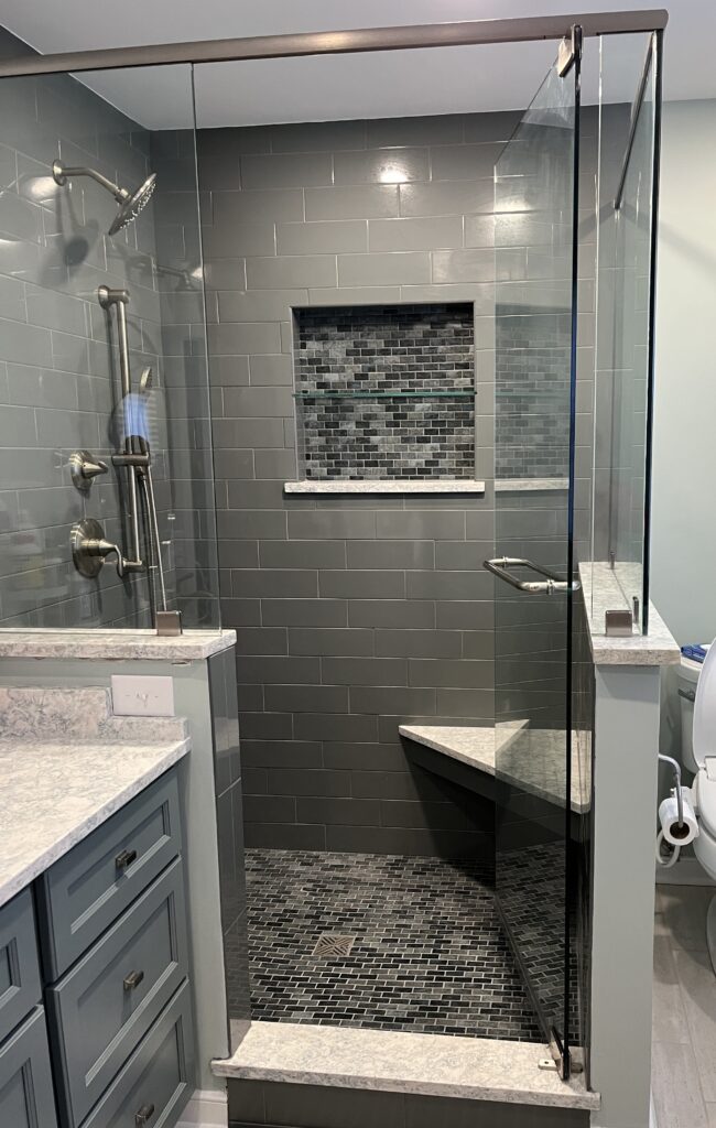 Modern glass shower with gray tile design.