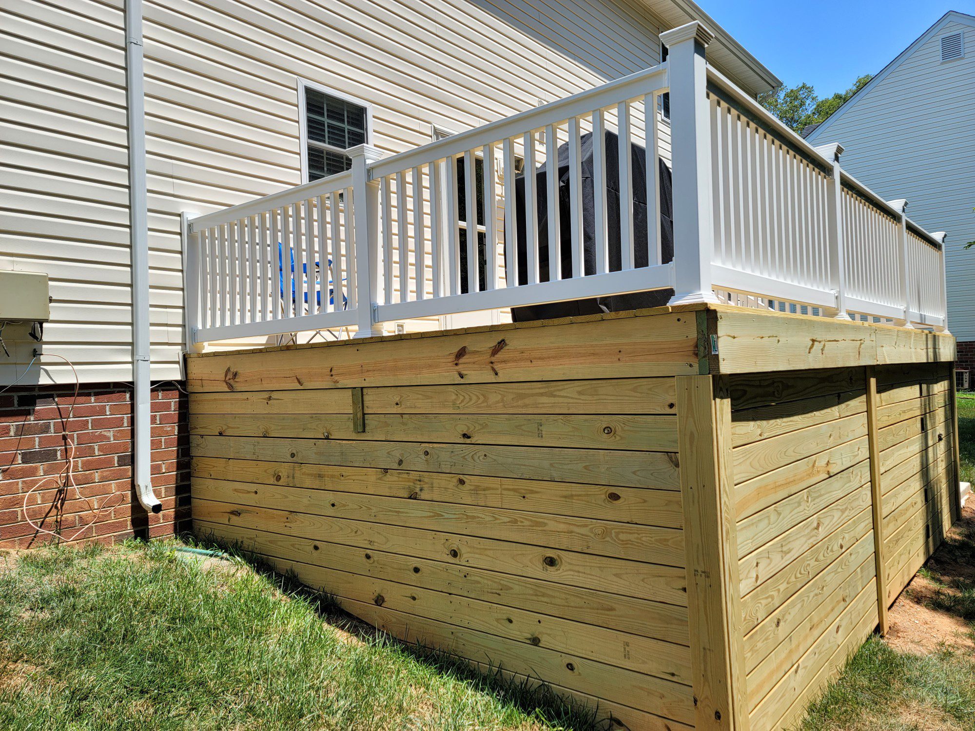 Wooden elevated deck with white railing.