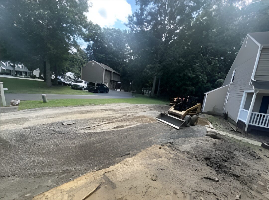 Skid steer on gravel driveway near house